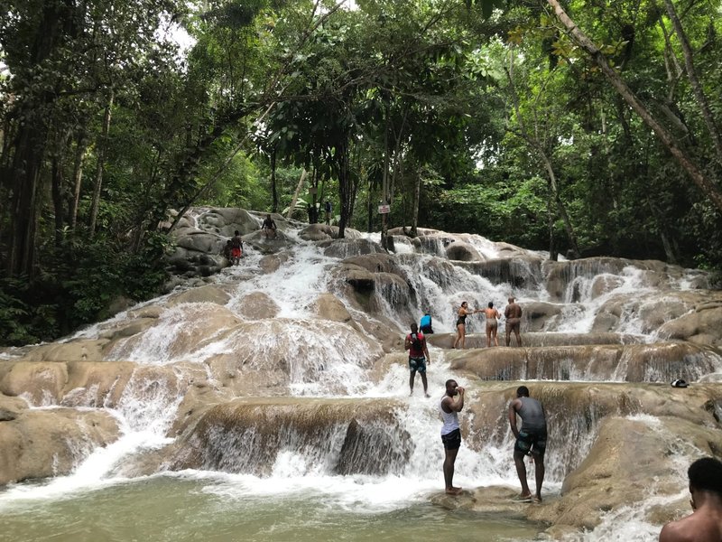 Wide view of Dunn’s River Falls with visitors climbing the terraces.