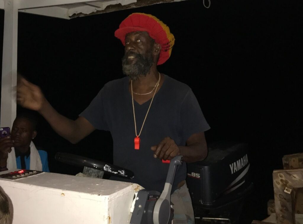 Boat captain giving the Luminous Lagoon Jamaica tour briefing on the water at night in Falmouth Jamaica