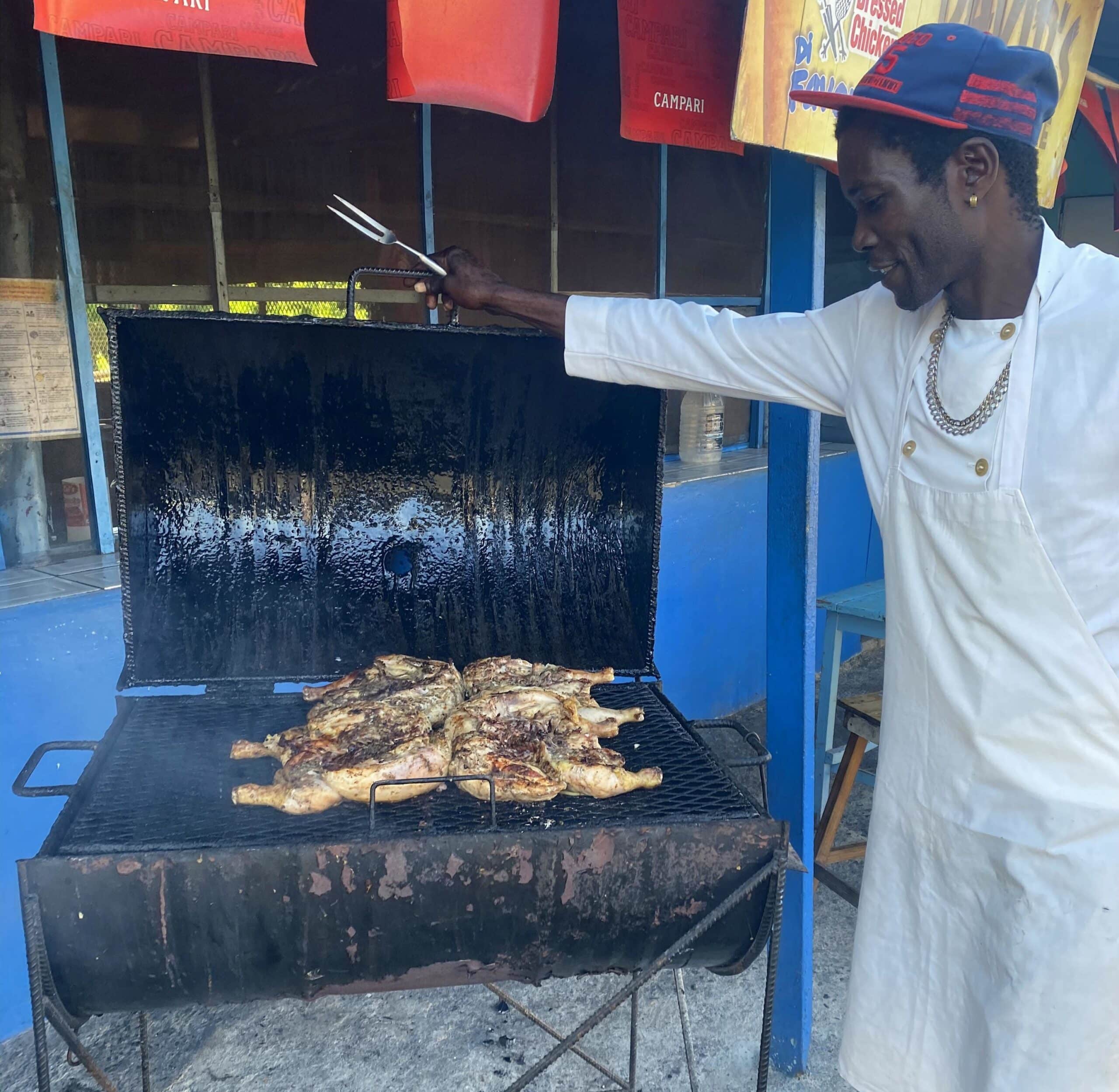 Jamaican jerk vendor tending chicken on a roadside grill in Boston Bay Portland