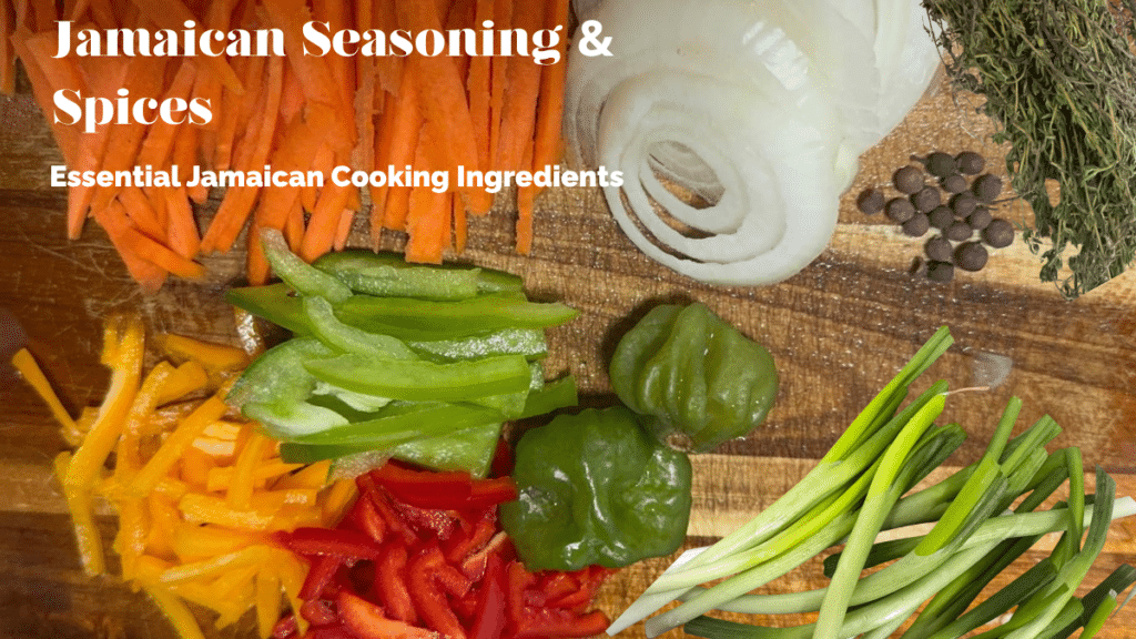 Fresh Jamaican cooking ingredients on a wooden cutting board — thyme, scallion, scotch bonnet pepper, pimento berries, carrots, and peppers