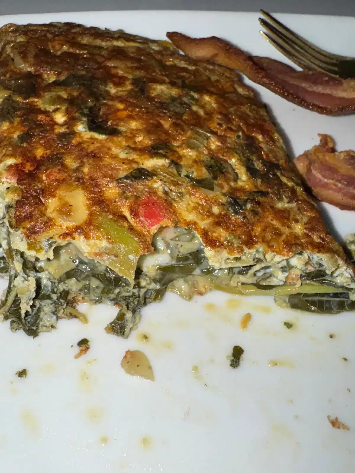 Cross-section of a Jamaican callaloo omelette showing the folded interior with steamed callaloo and egg